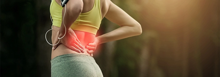 Acupuncture Flower Mound TX Low Back Pain A woman holding her lower back in pain.