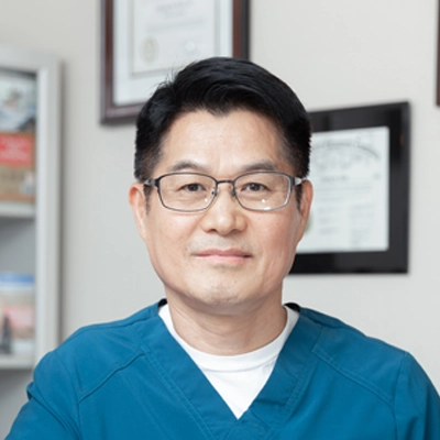 Dr. Choong Shim's headshot. He is wearing glasses and a teal shirt.