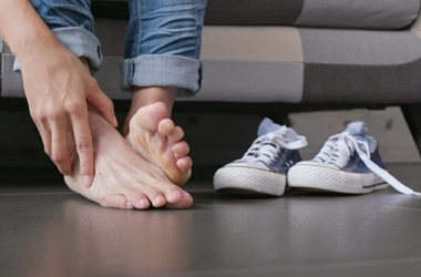 A person touching their foot.