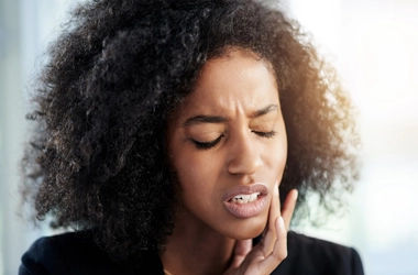 A person holding their jaw.